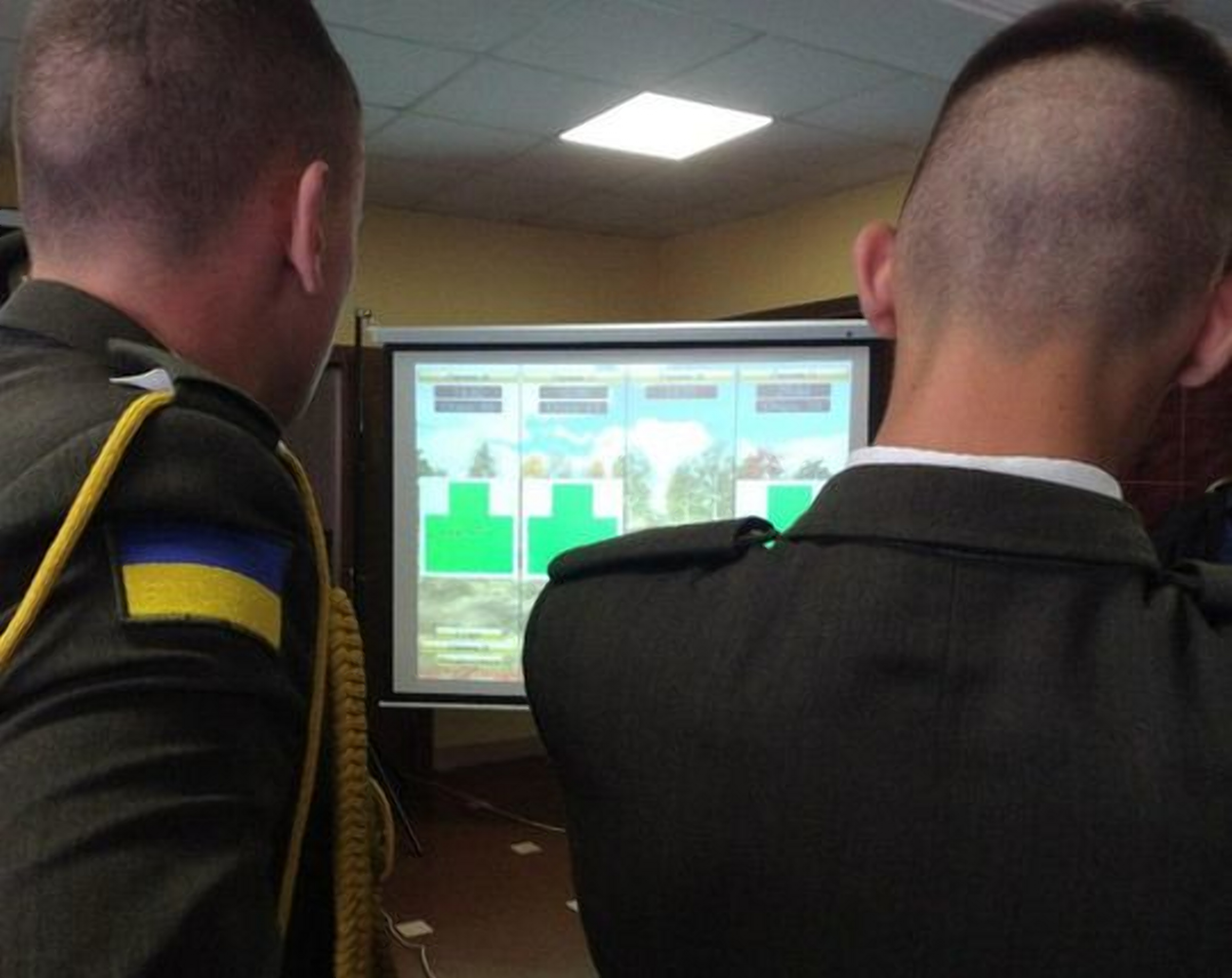 Двое военных Украины тренеруются стреляю в мишени на экране лазерного тира